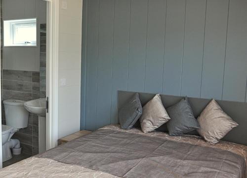 a bedroom with a bed with pillows on it at Riverside Holiday Park in Amberley
