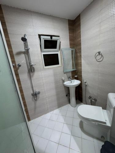 a bathroom with a toilet and a sink at المهيدب للشقق المخدومه 2 in Al Ahsa