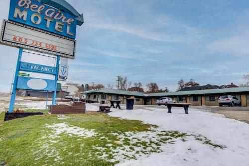 a sign for a motel with snow on the ground at Bel Aire Motel Chamberlain Near Missouri River I 90 in Chamberlain