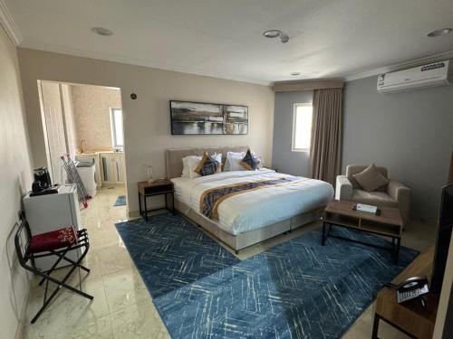 a bedroom with a bed and a couch and a chair at المهيدب للشقق المخدومه 2 in Al Ahsa