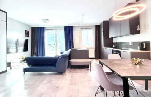 a living room with a blue couch and a table at FARFA Harmonia Oliwska in Gdańsk