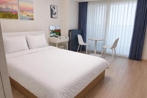 a bedroom with a bed and a table and chairs at Sokcho Summitbay 1209 "Ocean View" in Sokcho
