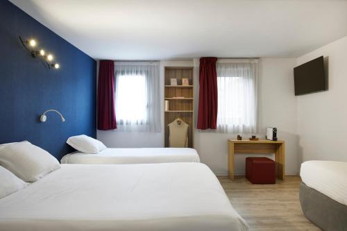 two beds in a room with blue walls at Hotel Restaurant Isidore by Soniho in Nice