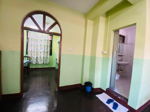 an empty room with an open door to a bathroom at Three Peaks Inn in Kathmandu