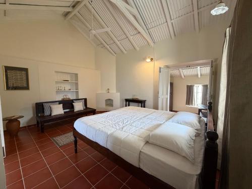 a bedroom with a large white bed in a room at Ellem House in Kotagiri