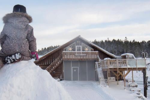 een persoon die in de sneeuw voor een hut staat bij Unik fjøsleilighet in Levanger