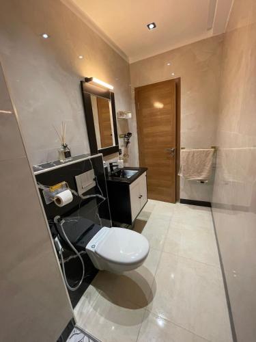 a bathroom with a toilet and a sink and a mirror at ADORA Apartment in Tangier