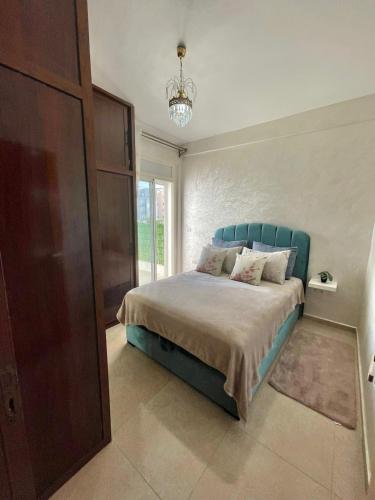 a bedroom with a bed with a blue head board at ADORA Apartment in Tangier