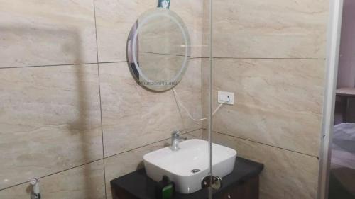 a bathroom with a sink and a mirror on a wall at Bhimtal Lakeview Cottage in Bhīm Tāl