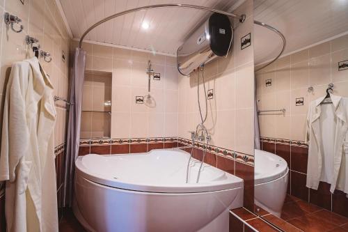 ヴォログダにあるHotel Vologdaのバスルーム(大型バスタブ、シャワー付)