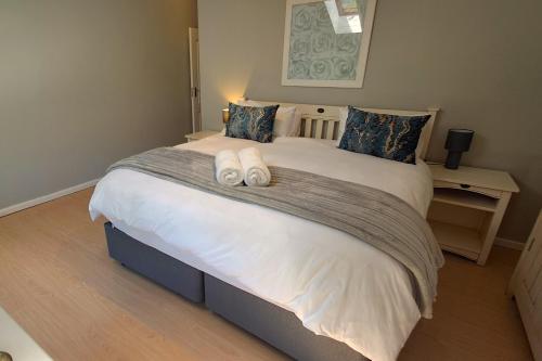 a bedroom with a large bed with two towels on it at 85 The Dunes in Keurboomstrand