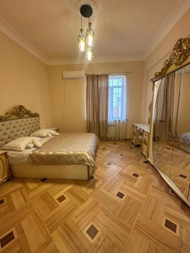 ein Schlafzimmer mit einem Bett und einem Holzboden in der Unterkunft Red Family Hotel in Vagharshapat