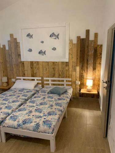 a bedroom with a bed and a wall with fish on it at Camera La Cinta in San Teodoro