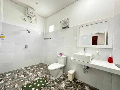 a white bathroom with a toilet and a sink at Ocean Villa Dive Resort - Tulamben in Tulamben