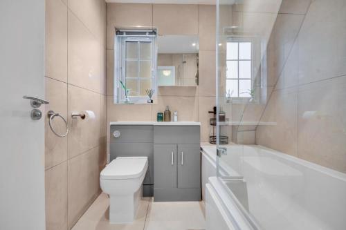 a bathroom with a toilet and a tub and a sink at Lovely 2-Bed House with parking in Broomfield