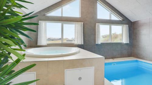a bathroom with a tub and a swimming pool at Villavilla 530 - Mommark, Sydjylland in Sarup
