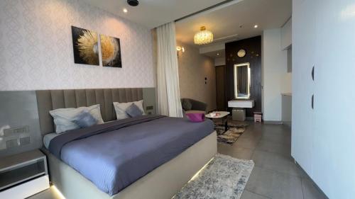 a bedroom with a large bed and a living room at Cozy corner by Luxury loft in Noida