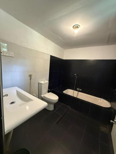 a bathroom with a sink and a toilet and a tub at Mango Three Resort in Anuradhapura