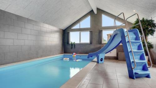 a indoor swimming pool with a slide in a room at Villavilla 546 - Hostrup Strand, Limfjorden in Spottrup