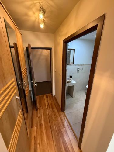 an open door to a bathroom with a mirror at K&I Panzió in Comolău