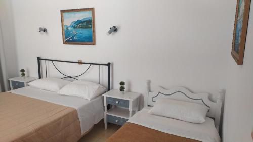 a bedroom with two beds and a picture on the wall at Nitsas studio's in Kremasti