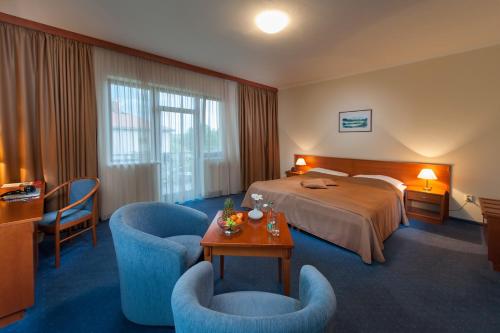 a hotel room with a bed and two chairs at April hotel Panorama in Rychnov nad Kněžnou