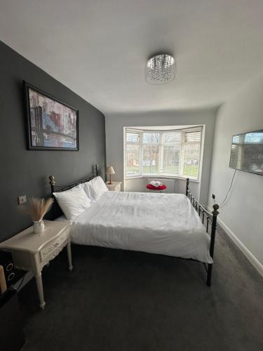 a bedroom with a large white bed and a window at Top House Sidcup in Streatham Hill