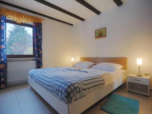 a bedroom with a large bed and a window at Haus 55 Fewo EG in Arrach