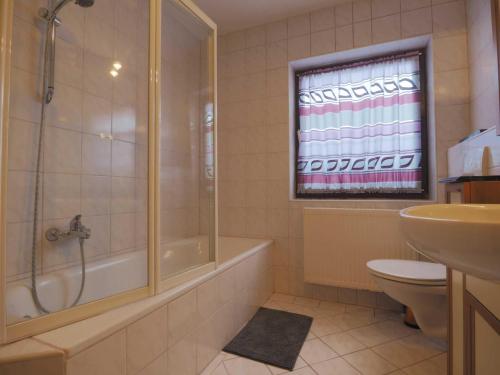 a bathroom with a shower and a toilet and a sink at Haus 55 Fewo EG in Arrach