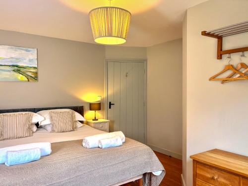 a bedroom with two beds and a chandelier at Greenwood Grange in Dorchester