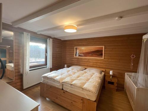 a bedroom with a bed in a room with a window at Haus 23 Seeblick in Arrach