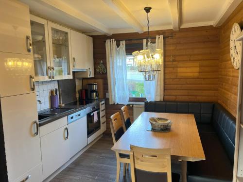 a kitchen with a table and chairs in a room at Haus 23 Seeblick in Arrach