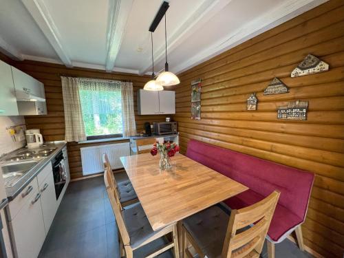 a kitchen with a table and chairs in a room at Haus 44 Feldblick in Arrach