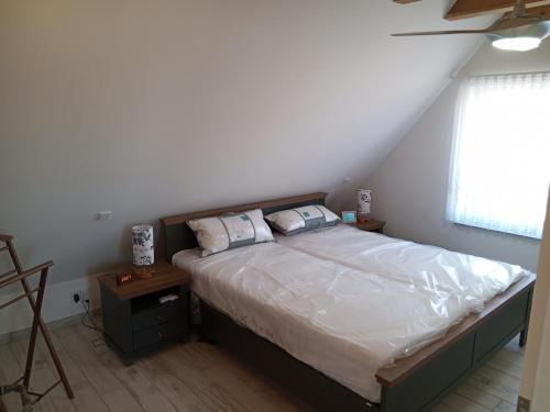 a bedroom with a bed with white sheets and a window at Fewo Zur Windmühle in Pegau