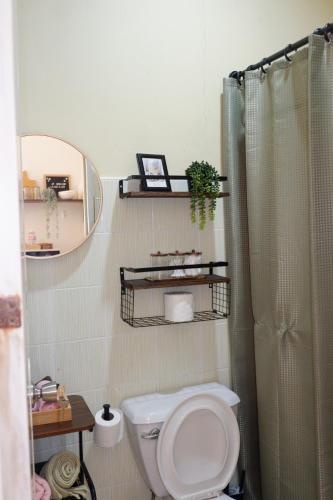 a bathroom with a toilet and a mirror and a shower at Villa Solaj Dumaguete in Aganan