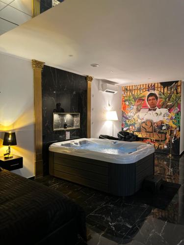 ein Schlafzimmer mit einer Badewanne mitten im Raum in der Unterkunft Spa2luxe - La Montana in Saint-Quentin