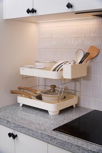 a kitchen with a shelf with dishes and utensils at KNV Apartment in Thu Dau Mot