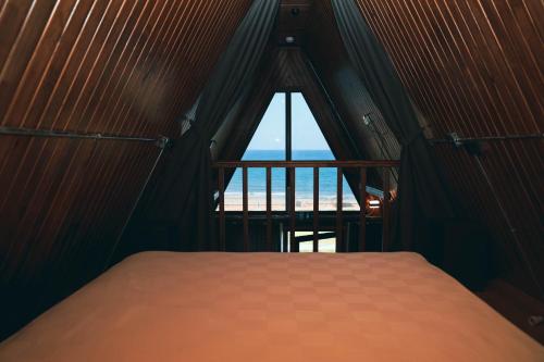 a bedroom with a window with a view of the beach at Akcasehir Sosyal Tesisleri in Akçakoca