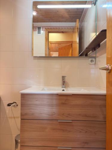 een badkamer met een wastafel en een spiegel bij Chimenea, confort moderno y madera - Falcó 2 in Pla de l'Ermita