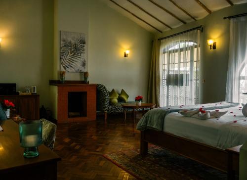 a bedroom with a bed and a living room with a fireplace at Saab Royale Resort in Kajiado