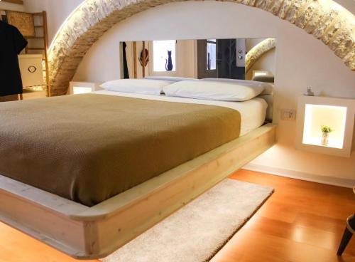 a bedroom with a large bed with an arch at Mariposa Grumo in Grumo Appula