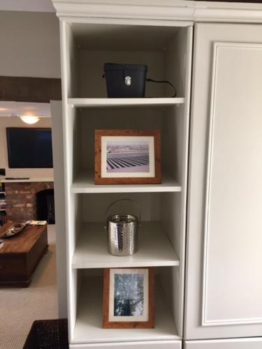 a white book shelf with photos and a picture at The Old Three Pigeons in Nesscliffe