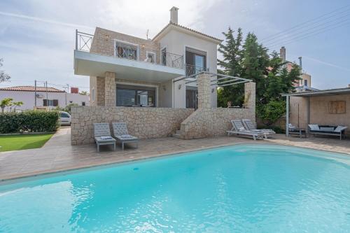 a villa with a swimming pool in front of a house at Tranquil house in Kipséli