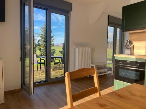 a kitchen with a table and a view of a patio at 4-Steine-Blick, Wohnung "Zur Kaiserkrone" in Schöna
