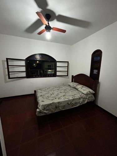 a bedroom with a bed and a ceiling fan at Casa Espaçosa em Unamar in Cabo Frio
