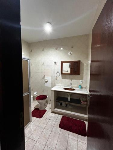 a bathroom with a toilet and a sink at Casa Espaçosa em Unamar in Cabo Frio