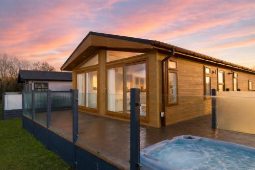 a house with a hot tub in the yard at Finest Retreats - Heron Luxury Lodge
