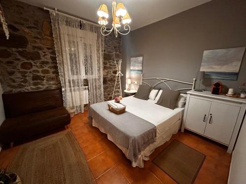 a bedroom with a bed and a chandelier at Hostal Casa San Nicolas in Molinaseca