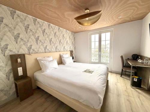 a bedroom with a large white bed with a ceiling at Best Western Hotel Restaurant Ile de France in Château-Thierry