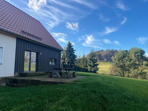 a building with a picnic table next to a field at 4-Steine-Blick, Wohnung "Zum Winterberg" in Schöna